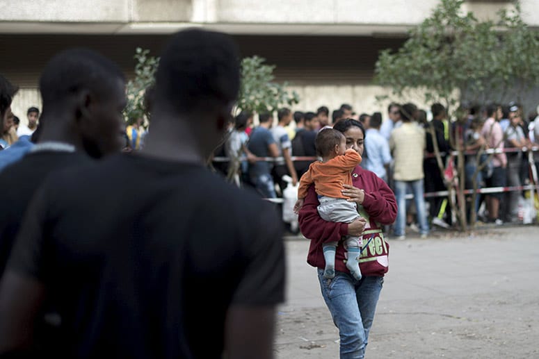 Menschen warten vor einem Sozialamt in Berlin: In Deutschland werden sie angesichts ihrer Menge zu Zahlen, die Kopfzerbrechen bereiten.