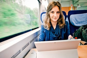 Keine Wohnung, dafür eine Bahncard: Leonie Müller sitzt in der Bahn an ihrem tragbaren Computer auf der Strecke zwischen Köln und Stuttgart.