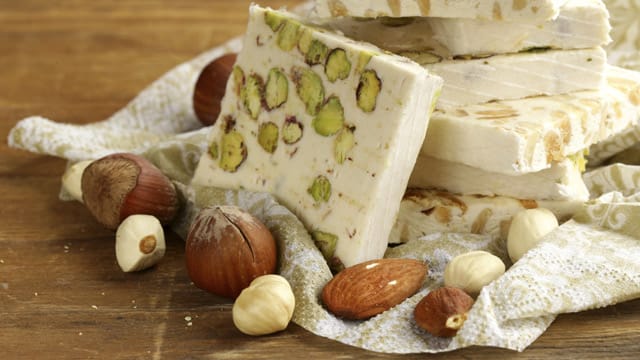 Weißer Nougat kann ganz unterschiedlich verfeinert werden: Pistazien, verschiedene Nüsse oder Früchte wie Kirschen machen ihn besonders lecker!