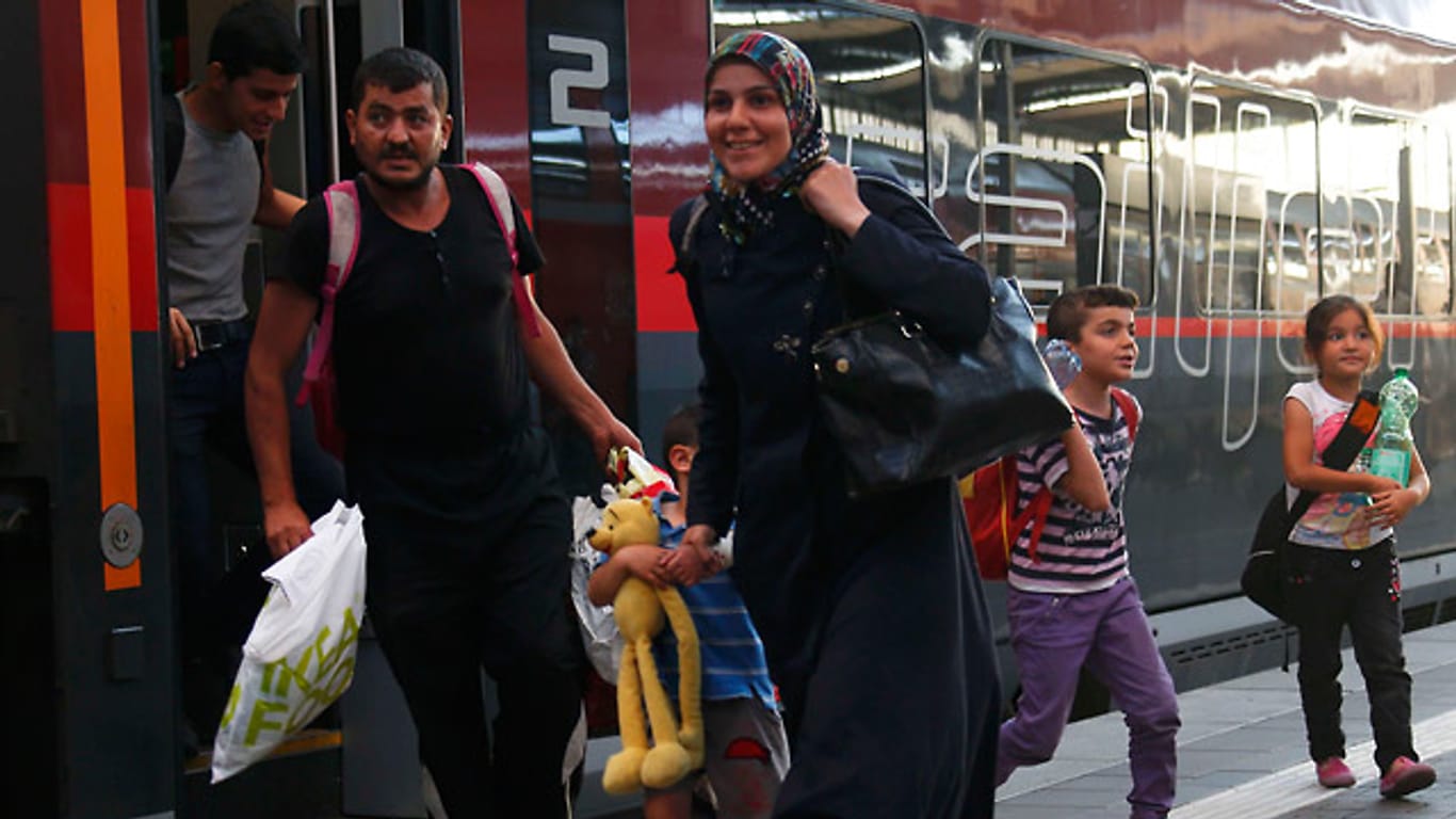Flüchtlinge aus Syrien erreichen erleichtert mit einem der ersten Züge aus Ungarn über Wien die bayerische Landeshauptstadt München.