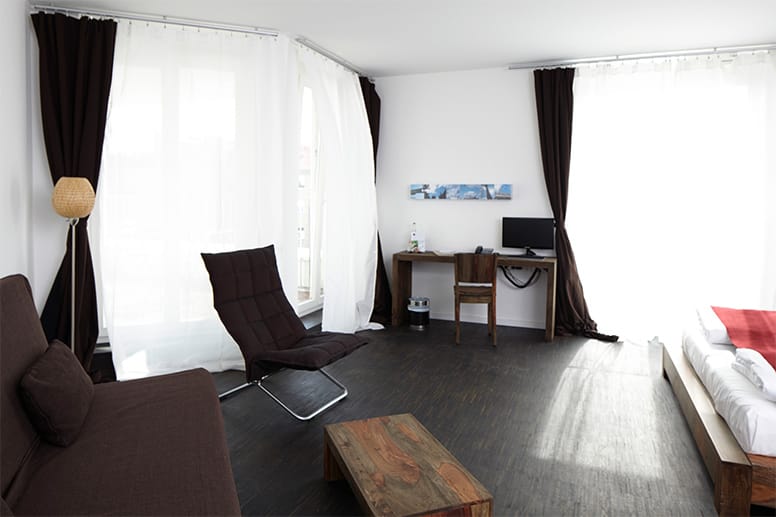 In ihren Hotelzimmern können Gäste auf dunklem Holzboden meditieren.
