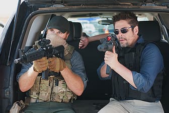 Alejandro (Benicio del Toro, r) und ein Mitglied der US-Spezialeinheit erwarten den Angriff des Kartells.