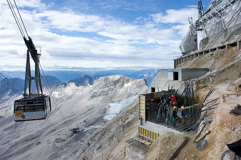 Die Gletscherseilbahn fährt auf der Zugspitze an den Bauarbeiten für ein neues Fundament vorbei.