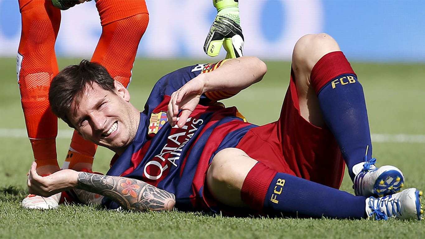 Lionel Messi verzieht das Gesicht vor Schmerzen.