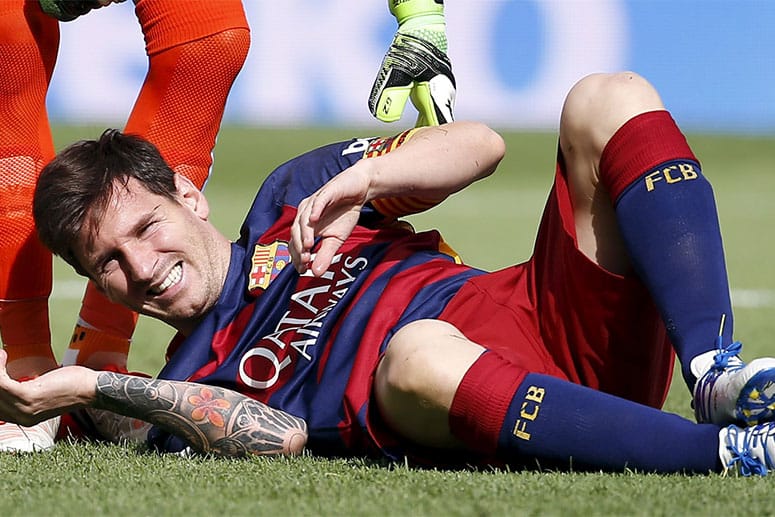 Lionel Messi verzieht das Gesicht vor Schmerzen.