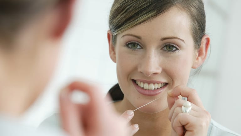 Bei der Zahnpflege sollten auch die Zahnzwischenräume gründlich gereinigt werden. Am besten geht das mit Zahnseide.