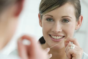 Bei der Zahnpflege sollten auch die Zahnzwischenräume gründlich gereinigt werden. Am besten geht das mit Zahnseide.