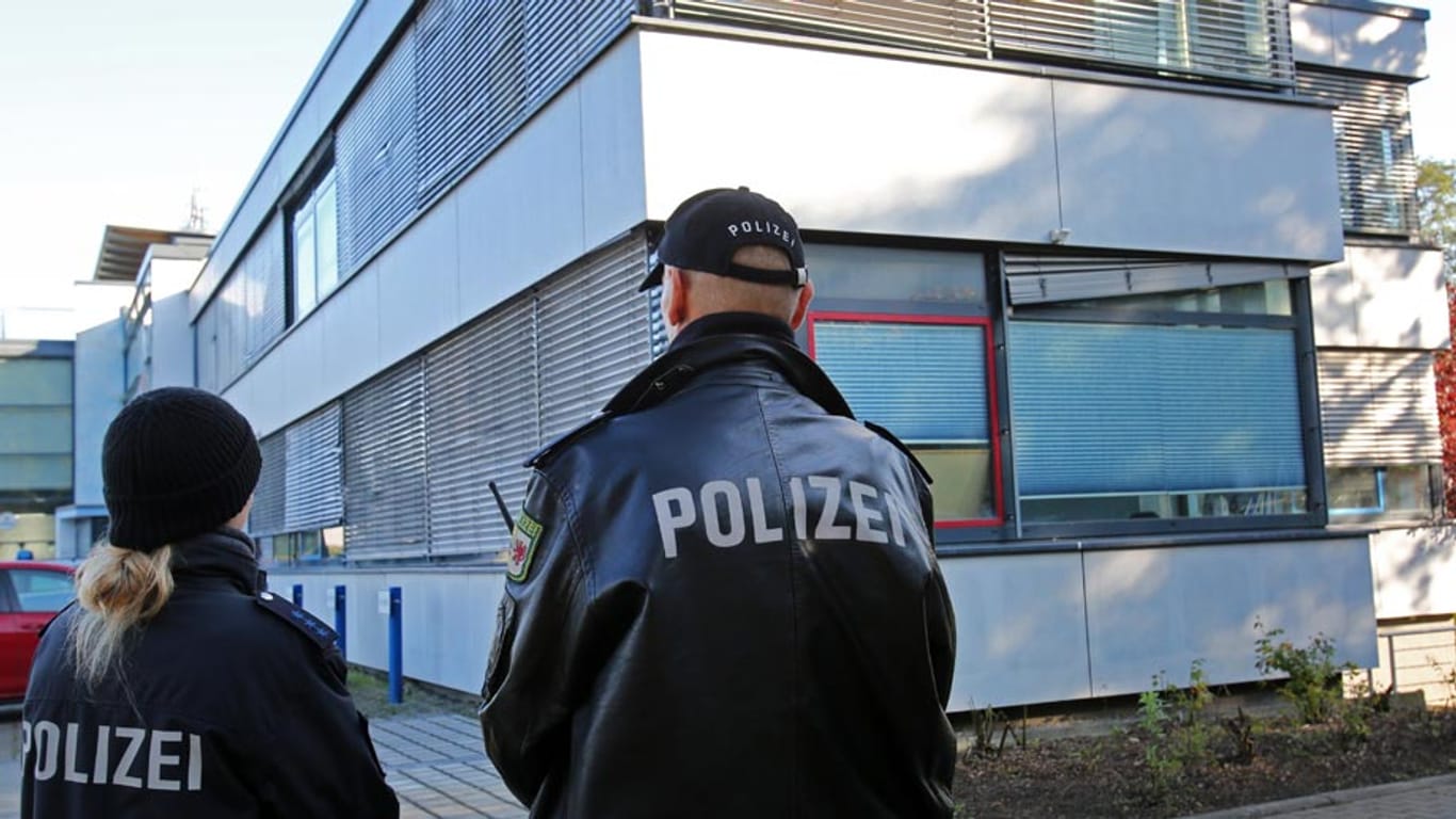 Polizisten stehen vor der verschlossenen Geschäftsstelle des FC Hansa Rostock Wache.