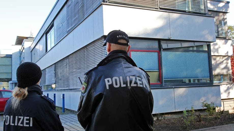 Polizisten stehen vor der verschlossenen Geschäftsstelle des FC Hansa Rostock Wache.