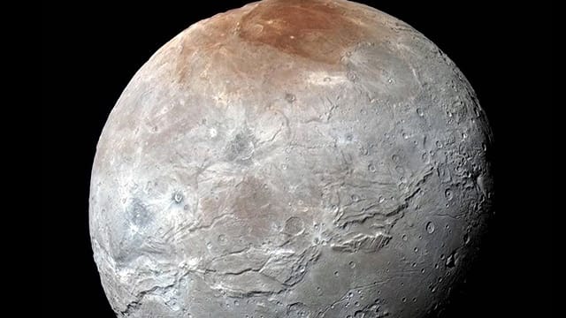 Auf der Oberfläche von Charon sind riesige Schluchten zu erkennen.