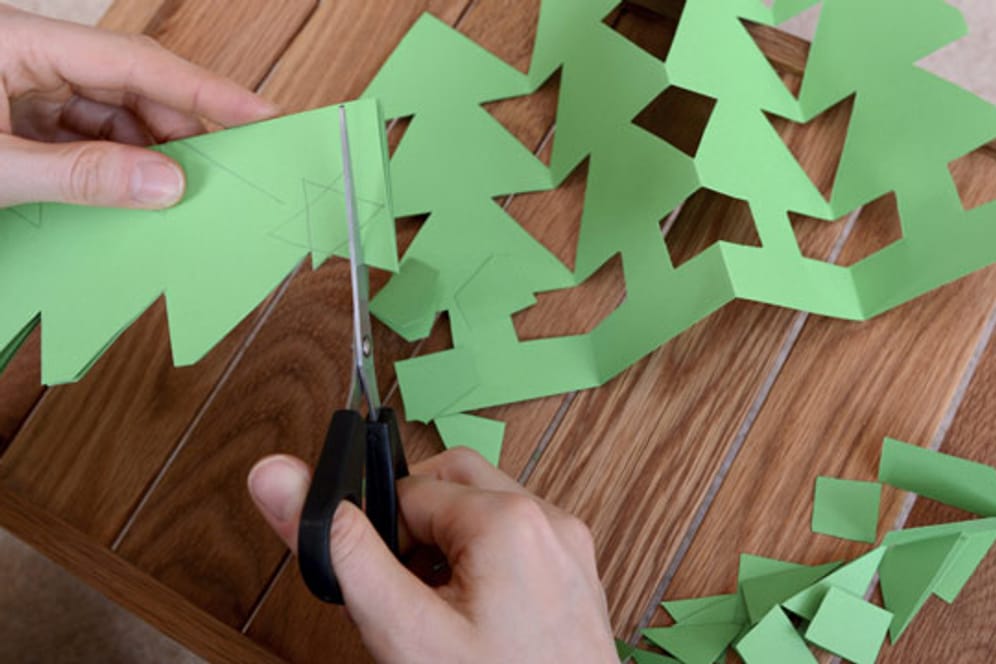 Um die Pappbecher zu verzieren, können Sie weihnachtliche Motive wie Tannenbäume, Schneeflocken oder Sterne ausschneiden.