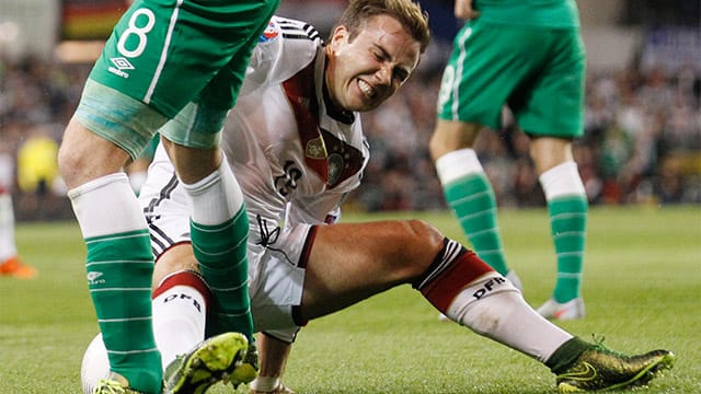 Mario Götze geht mit schmerzverzerrtem Gesicht zu Boden.