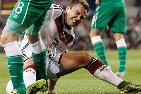 Mario Götze geht mit schmerzverzerrtem Gesicht zu Boden.