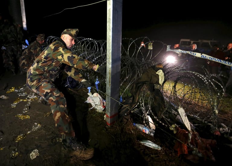 Ungarische Soldaten schließen den Zaun an der Grenze zu Kroatien.