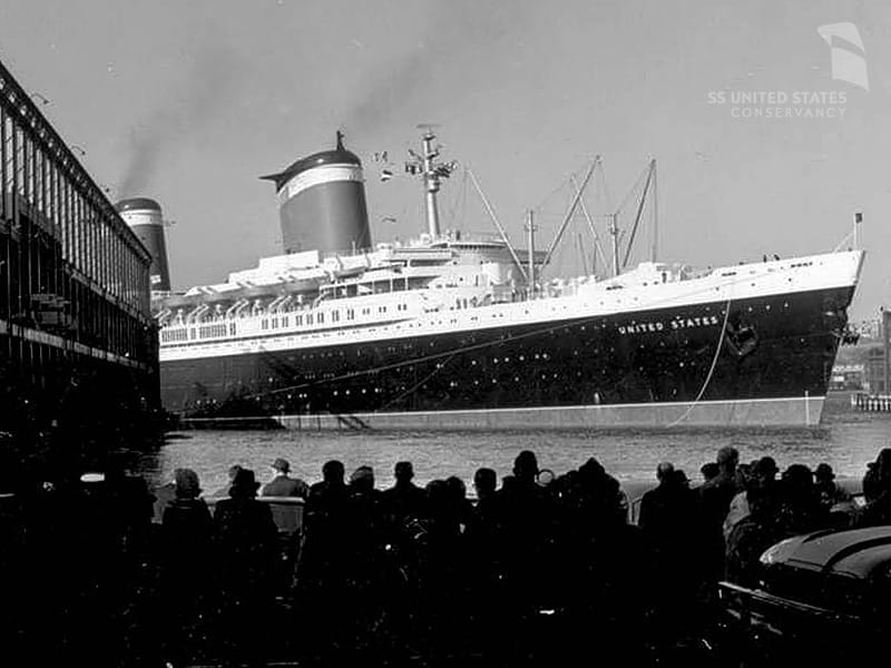 Ein Bild aus längst vergangenen Zeiten: Die Schlepperboote streiken, die "SS United States" legt trotzdem mühelos und unter dem Applaus der Schaulustigen im Heimathafen New York an Pier 86 am Hudson River an.