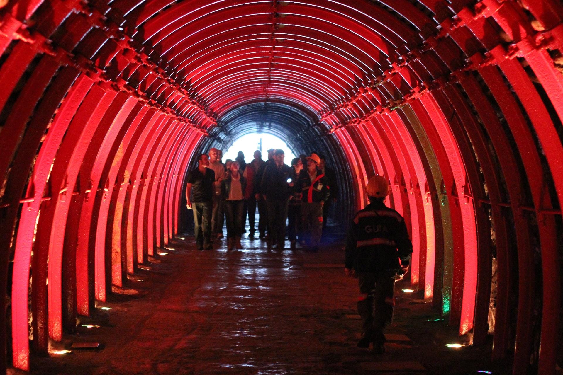 Abstieg in die Unterwelt: Durch diesen rot beleuchteten Tunnel kommen Besucher in die größte Salzkathedrale der Welt.