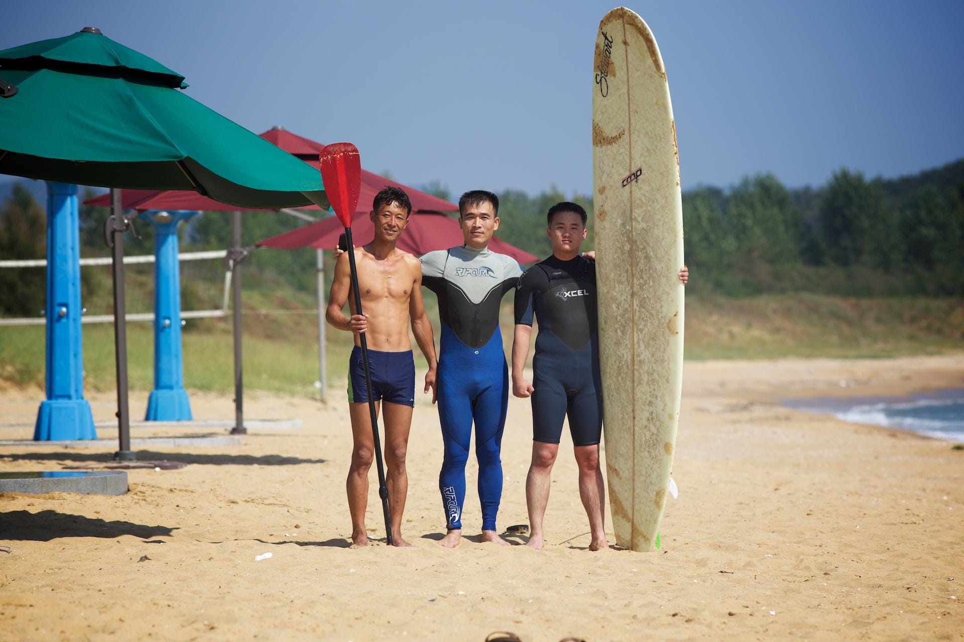 Schüler der örtlichen Surfschule am Majon Beach: Sie studieren die Wellen und folgen den Anweisungen der Lehrer...
