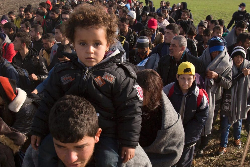Flüchtlinge auf einem Feld nach ihrer Ankunft in Slowenien.