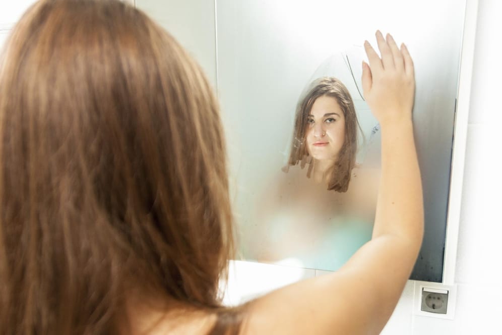 Ein beschlagener Spiegel im Bad ist lästig. Doch mit der Hand wischt man besser nicht über das Glas.