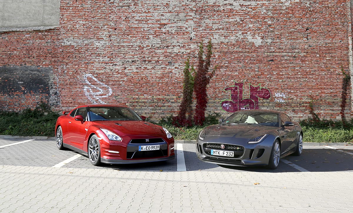 Unsere beiden Testkandidaten sind faszinierende Sportwagen und haben trotz ähnlichen Grundwerten ganz unterschiedliche Charaktere. Es treten an: Nissan GT-R Premium Edition mit der Perleffektlackierung "Sunset Red" gegen den Jaguar F-Type R AWD in "Ammonite Grey Metallic".
