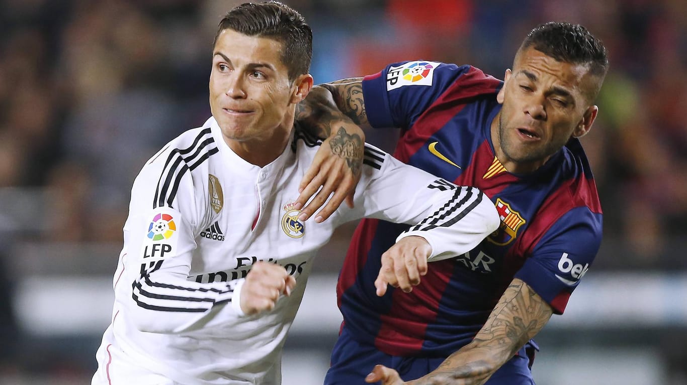 Real-Star Cristiano Ronaldo (li.) und Dani Alves vom FC Barcelona behaken sich im Zweikampf.