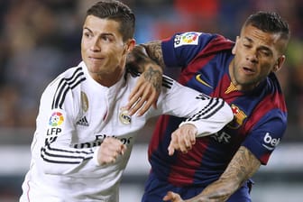Real-Star Cristiano Ronaldo (li.) und Dani Alves vom FC Barcelona behaken sich im Zweikampf.