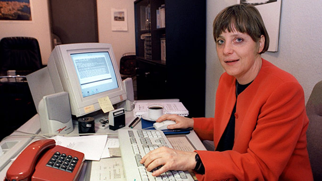 Angela Merkel 1991 in ihrem Wahlkreisbüro in Stralsund. Schon damals zeigt sich ihre Vorliebe für Blazer in kräftigen Farben - in diesem Fall sogar passend zum Telefon.
