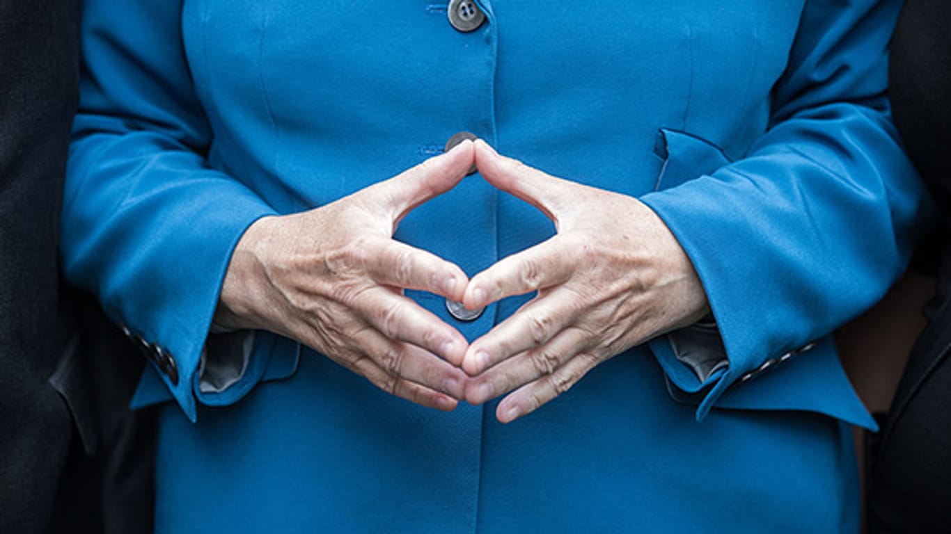 Wohin mit den Händen? Während Männer schon mal nonchalant eine Hand in die Hosentasche stecken können, müssen sich Frauen etwas anderes überlegen. Die Queen trägt bevorzugt Handtasche - Merkel hat sich für die "Raute der Macht" entschieden.