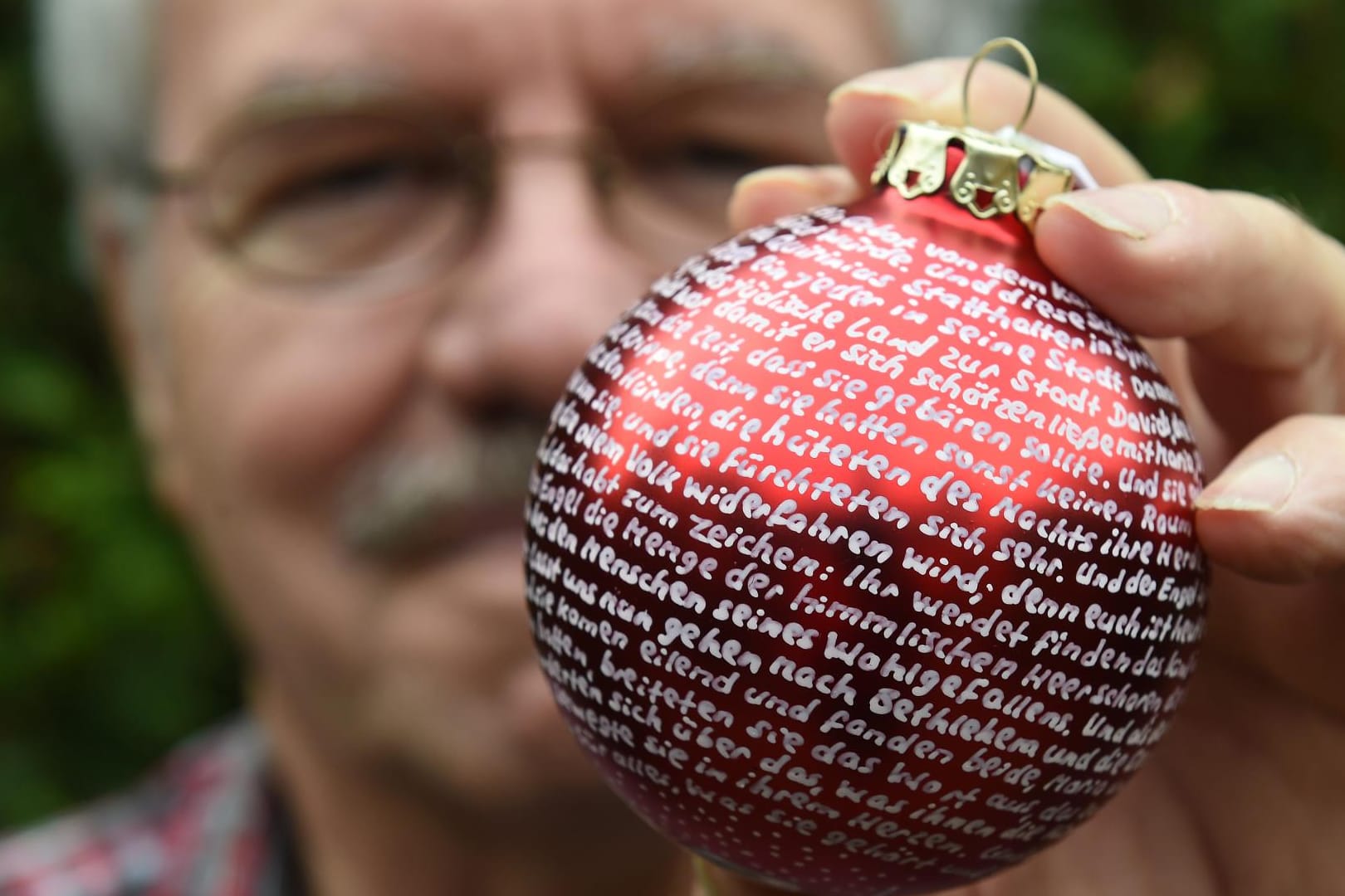 In mühevoller Handarbeit beschriftet Louis Pfeiffer Weihnachtskugeln.