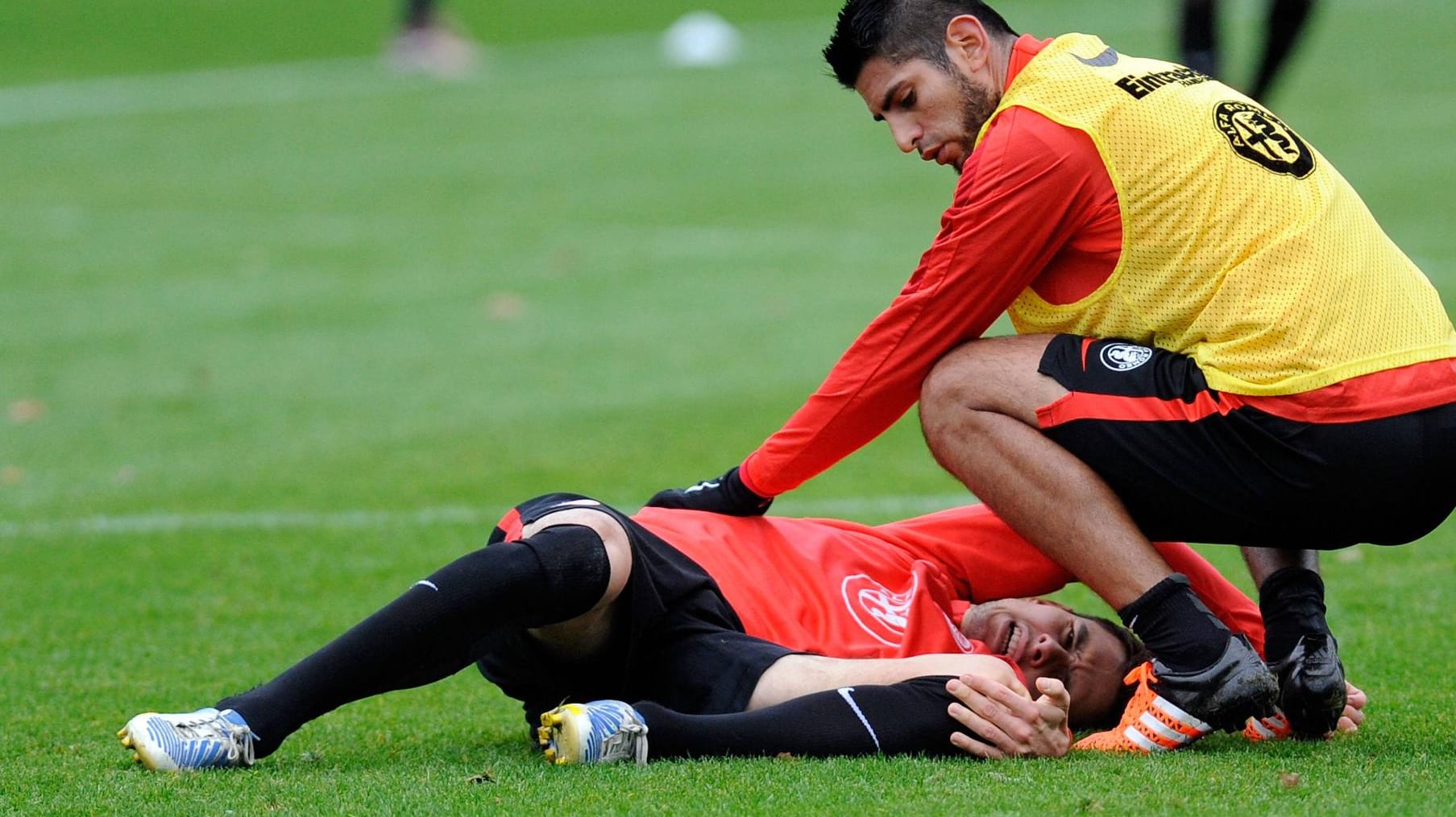 Johannes Flum liegt nach seinem Trainingsunfall auf dem Boden, Carlos Zambrano kümmert sich um ihn. Johannes Flum liegt nach seinem Trainingsunfall auf dem Boden, Carlos Zambrano kümmert sich um ihn.