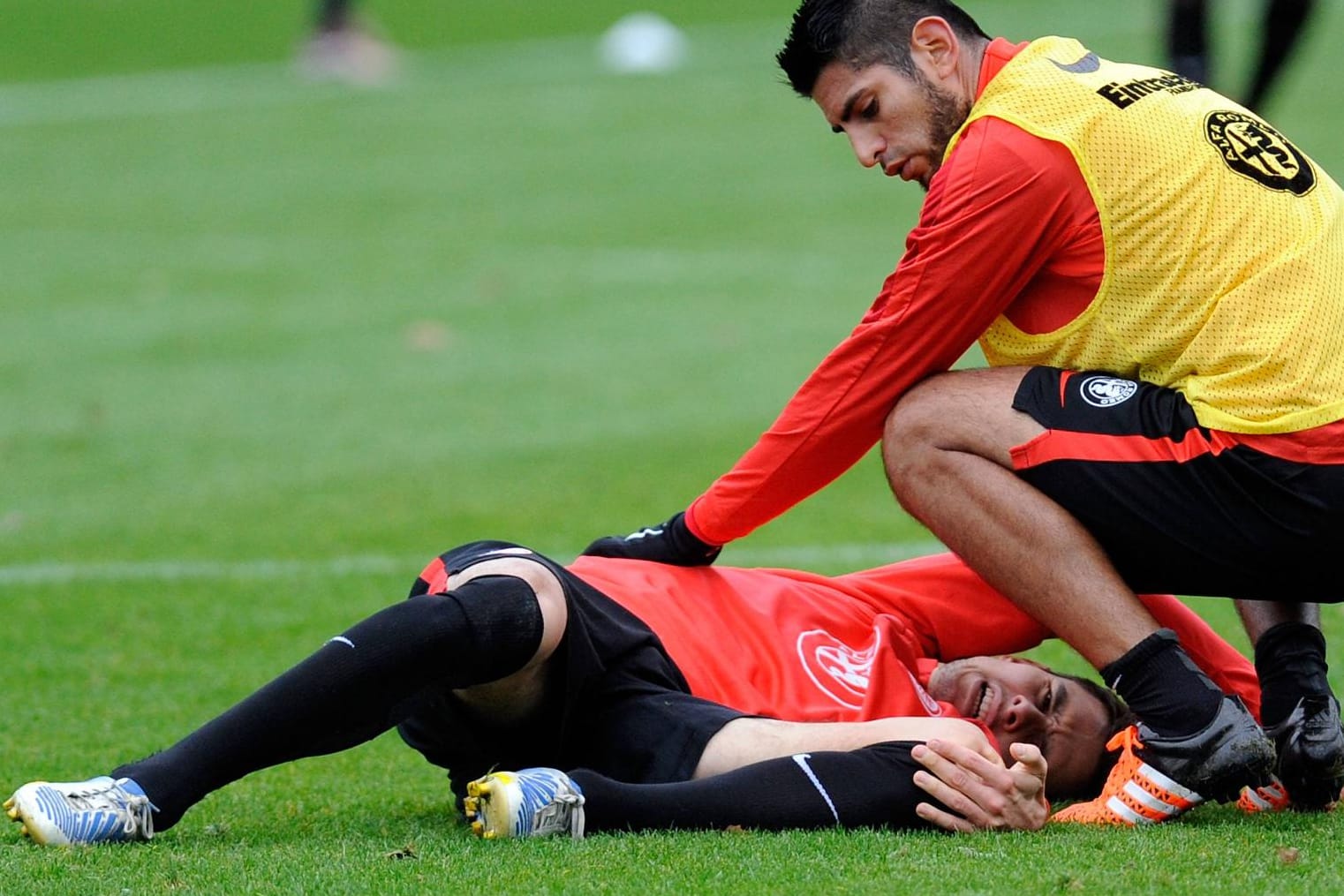 Johannes Flum liegt nach seinem Trainingsunfall auf dem Boden, Carlos Zambrano kümmert sich um ihn.