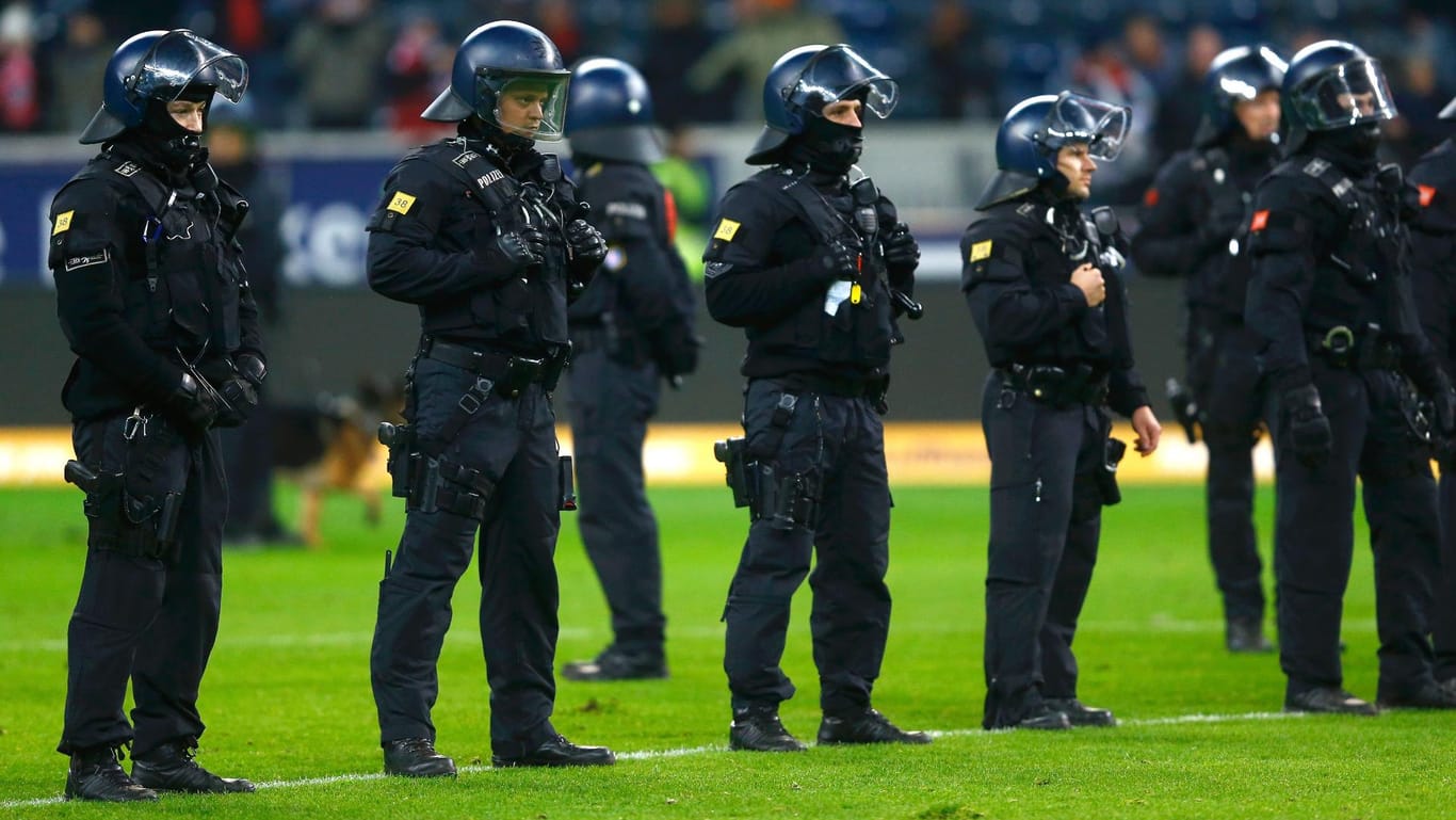 Polizisten stehen nach dem Derby zwischen Eintracht Frankfurt und dem SV Darmstadt 98 auf dem Spielfeld.