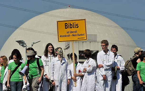 Mit Gasmasken und Schutzanzügen demonstrieren Greenpeace-Aktivisten vor dem hessischen Atomkraftwerk Biblis in Hanau.
