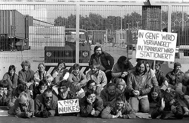 1983: Mitglieder der Grünen, darunter auch Joschka Fischer (rechts neben dem Schild "No Nukes"), blockieren ein US-Militärgelände im Frankfurter Stadtteil Hausen, das nach ihren Informationen für die Montage von Pershing II-Raketen vorgesehen sein sollte.