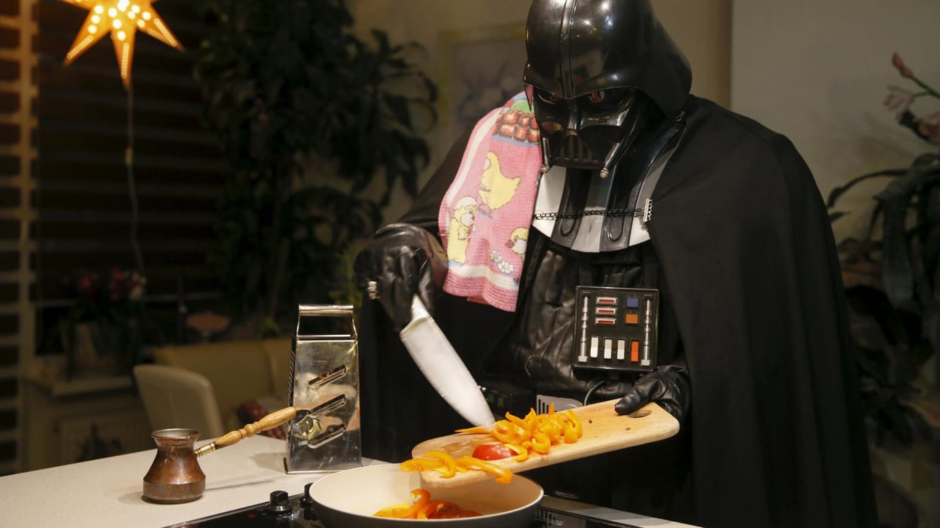 Herr Vader bereitet das Abendessen zu. Im Hintergrund leuchtet die Weihnachts-Deko.