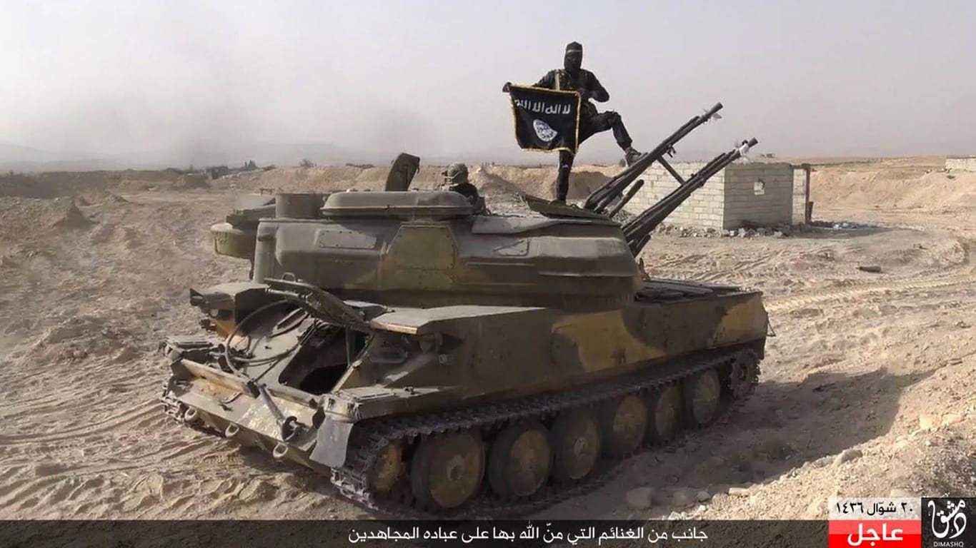 Ein Kämpfer des Islamischen Staats posiert auf einem von der syrischen Armee erbeuteten Panzer in der Nähe von Palmyra.