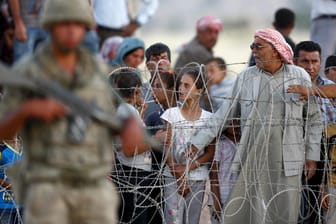 Syrische Kurden aus Kobane warten vor der Grenze zur Türkei. Das Land soll bislang gut zwei Millionen Flüchtlinge aufgenommen haben.
