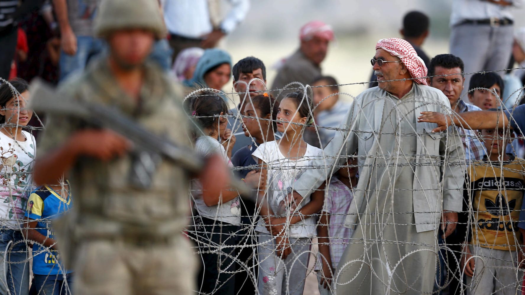 Syrische Kurden aus Kobane warten vor der Grenze zur Türkei. Das Land soll bislang gut zwei Millionen Flüchtlinge aufgenommen haben.