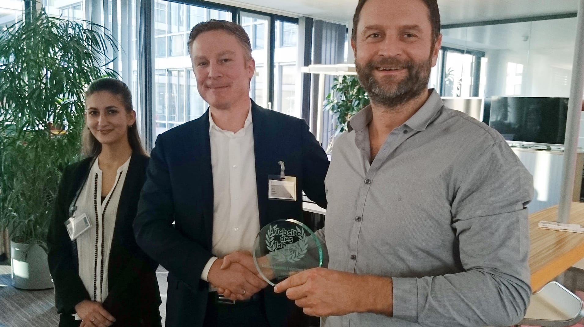 Sascha Hornung (r.), Chefredakteur von t-online.de, nimmt die Auszeichnung von Thomas Marteijn und Diána Tóth von MetrixLab entgegen.