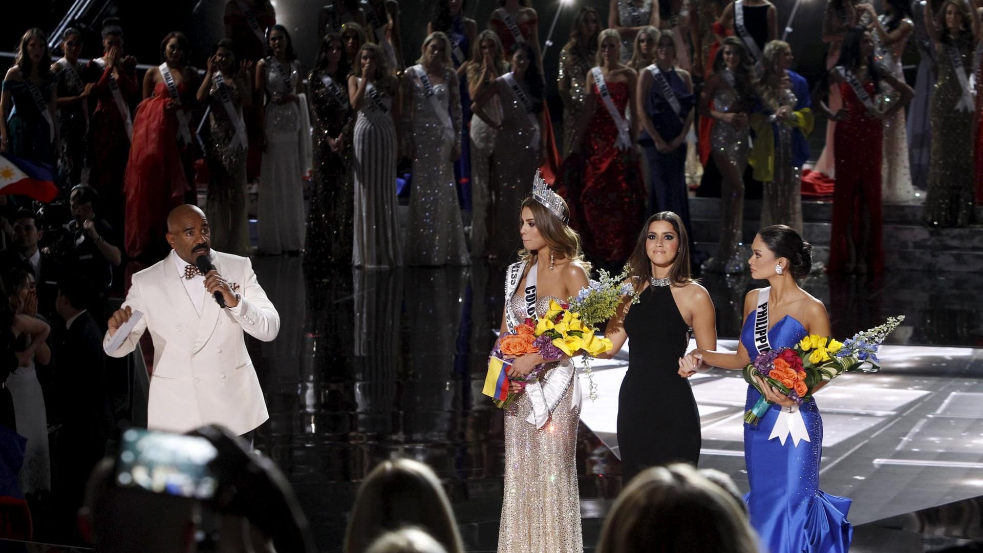 Der Moment der Wahrheit. Der peinlich berührte Moderator Steve Harvey erklärt seinen Fehler. Er habe eine falsche Gewinnerin vorgelesen. Nicht Miss Kolumbien (l.) sei die neue Miss Universe, sondern die Deutsch-Philippinerin Pia Alonzo Wurtzbach (r.).