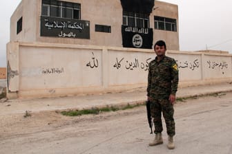 Kurdischer Kämpfer vor dem eroberten IS-Hauptquartier im syrischen Al-Hawl.