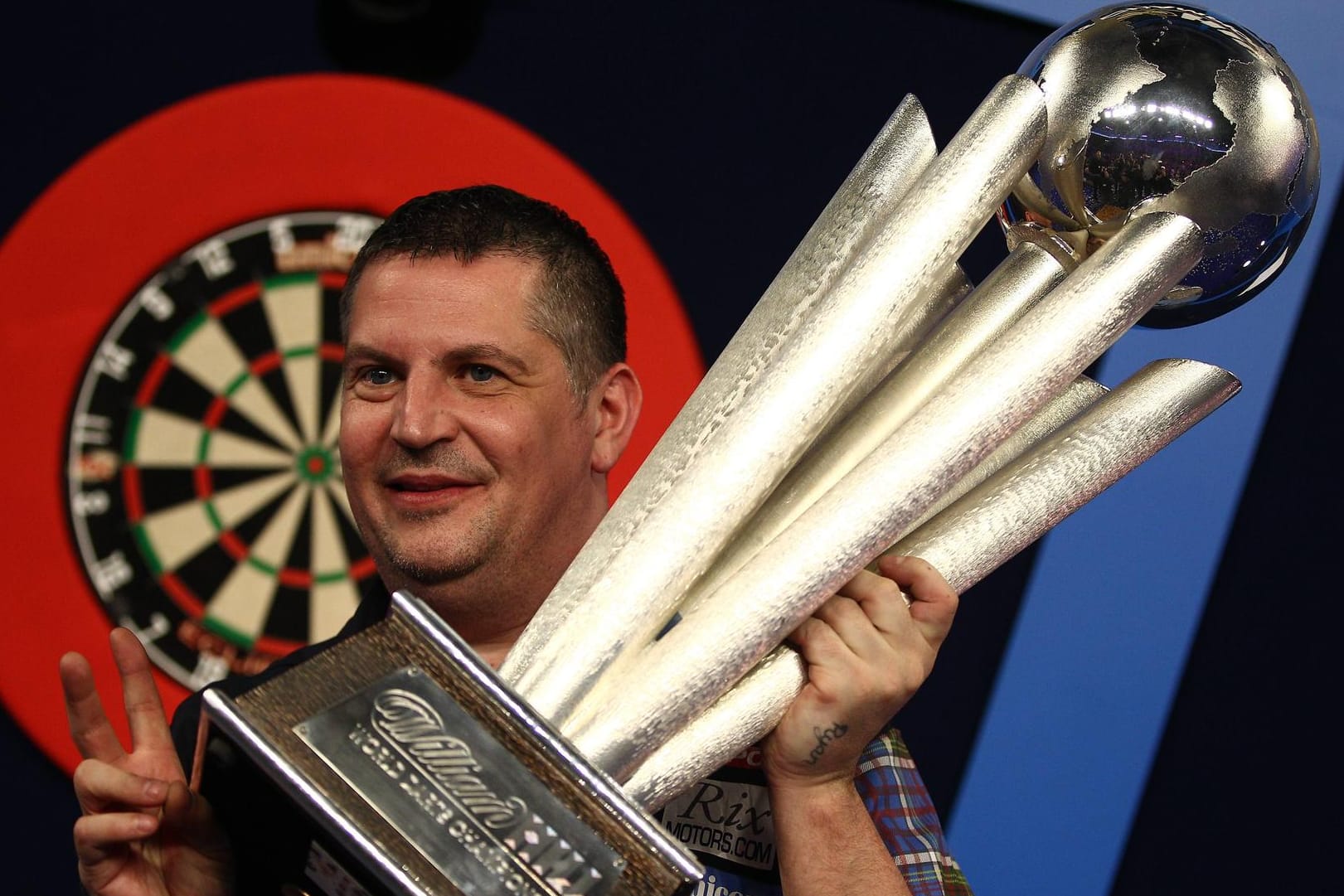 Gary Anderson posiert mit dem Riesenpokal als alter und neuer Weltmeister.