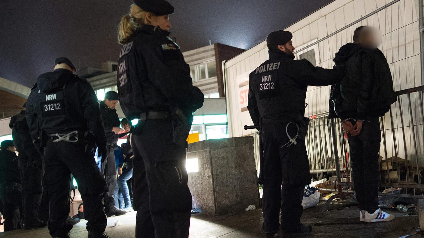 Polizisten kontrollieren am 5. Januar eine verdächtige Personen vor dem Kölner Hauptbahnhof. In der Silvesternacht haben dort Männer Dutzende Frauen sexuell belästigt und ausgeraubt.