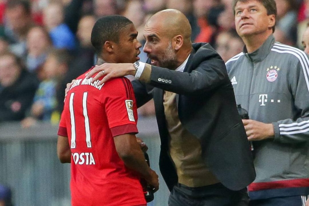 Pep Guardiola (re.) gibt Douglas Costa im Spiel Anweisungen.