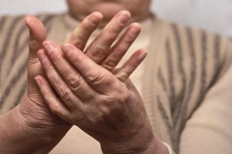Eine Frau massiert sich die Hände: Bei der Weißfingerkrankheit sind die Gefäße schlecht durchblutet.