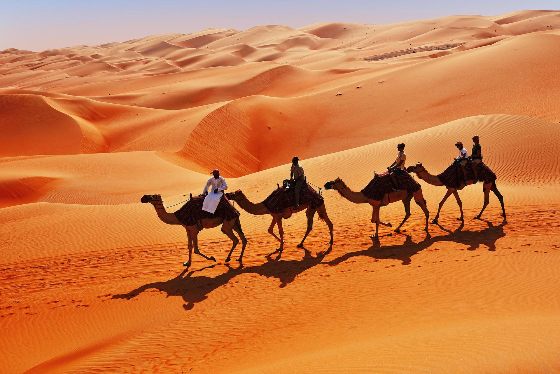 Ungewohnt hoch und wackelig: Touristen beim Kamelritt durch die Wüste Empty Quarter.