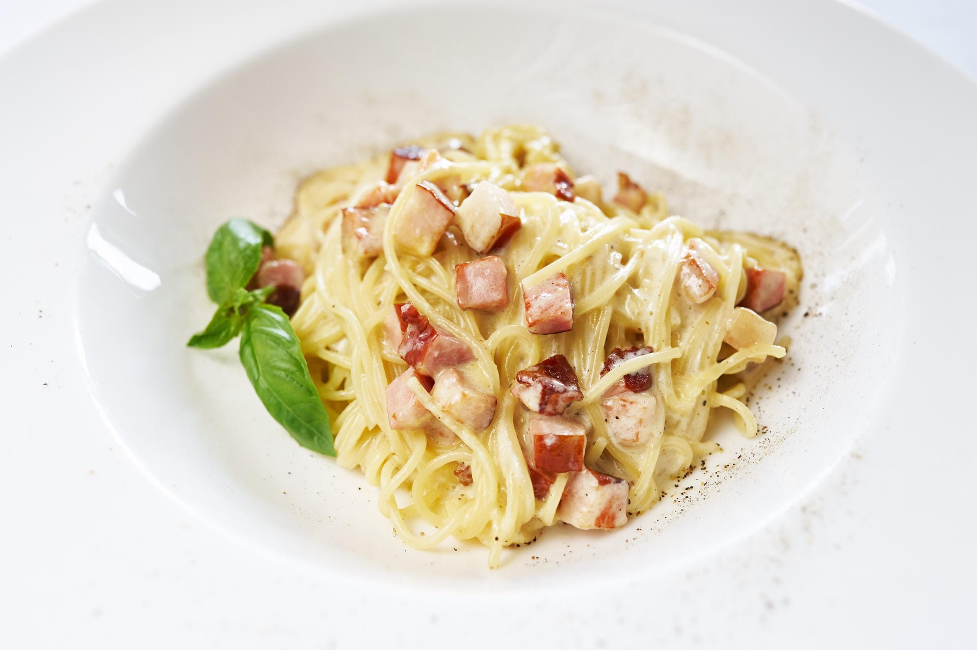 Spaghetti Carbonara ist ein Klassiker der Region Latium. Bei deutschen Italienern kommt das Traditionsgericht oft mit Sahnesauce und Kochschinkenstreifen, weil's einfach zu machen ist und sehr günstig im Einkauf. Den Deutschen schmeckt's trotzdem.