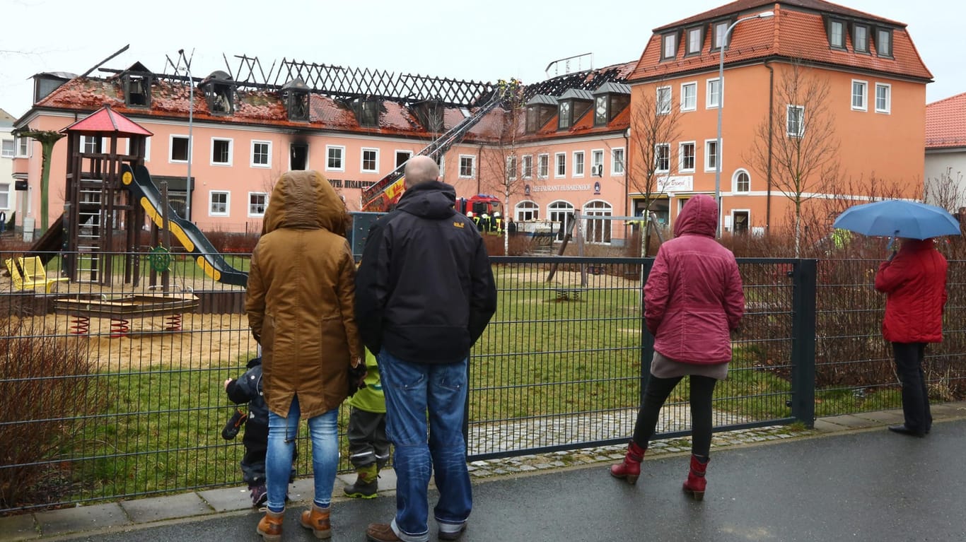Passanten vor der abgebrannten künftigen Flüchtlingsunterkunft in Bautzen.