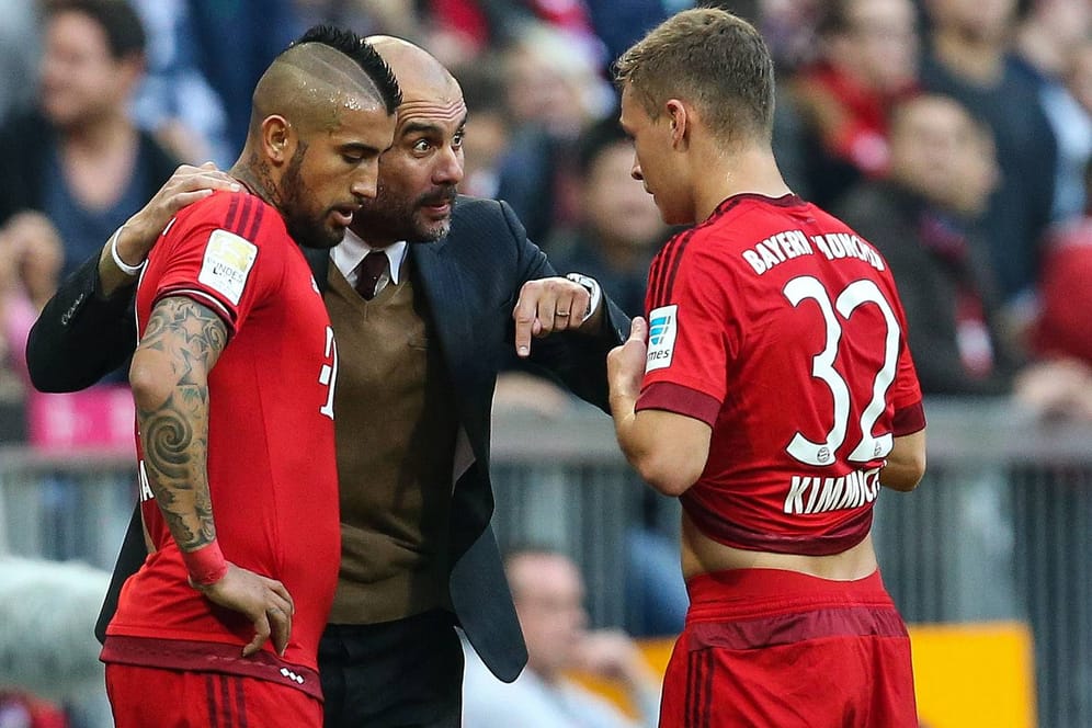 Bayern-Coach Pep Guardiola gibt seinen Spielern Arturo Vidal (li.) und Joshua Kimmich Instruktionen.