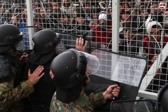 Mazedonische Polizisten in Gevgelija versuchen Flüchtlinge daran zu hindern, einen Grenzzaun zu durchbrechen.